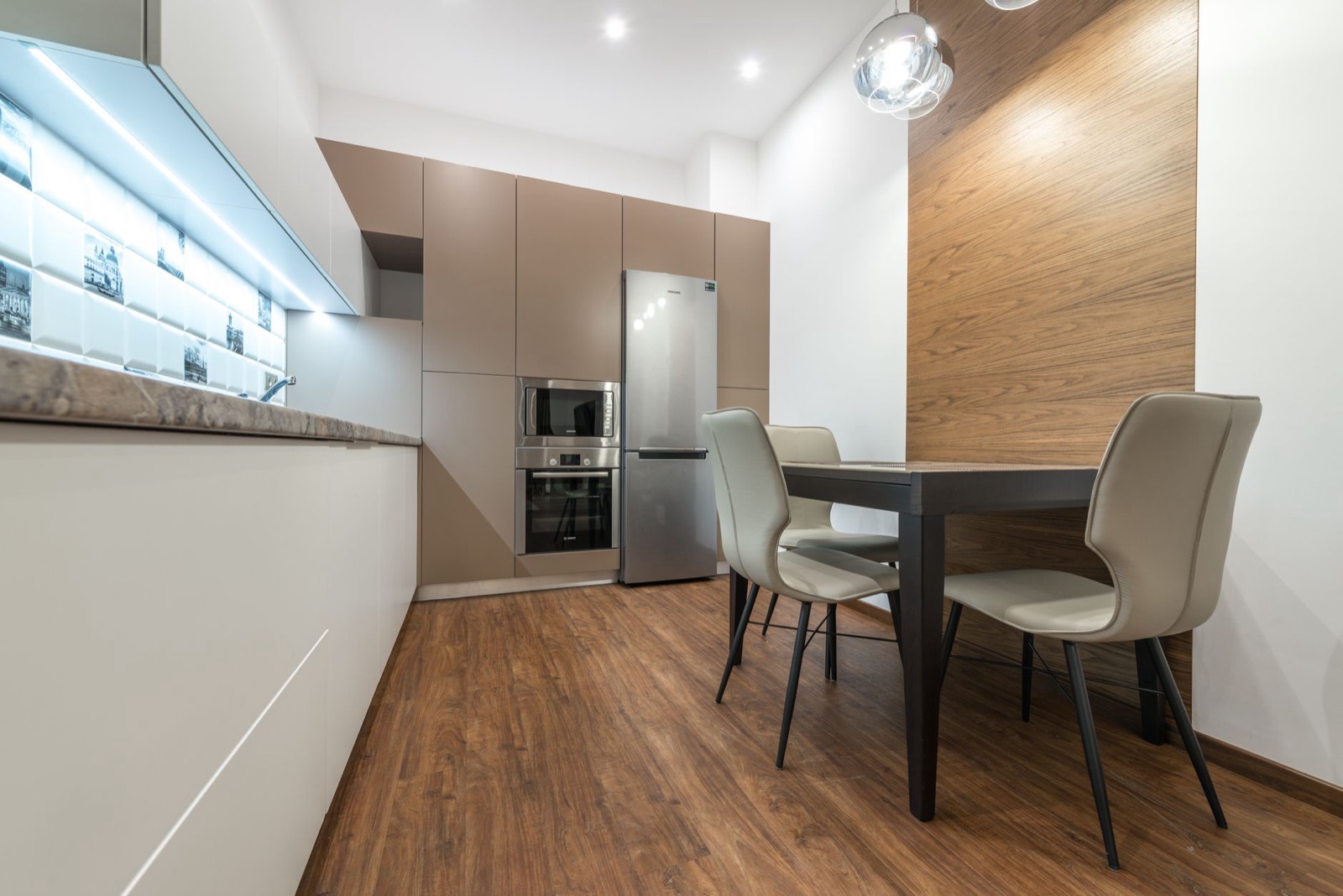Furnished apartment kitchen with full-size refrigerator and dining table