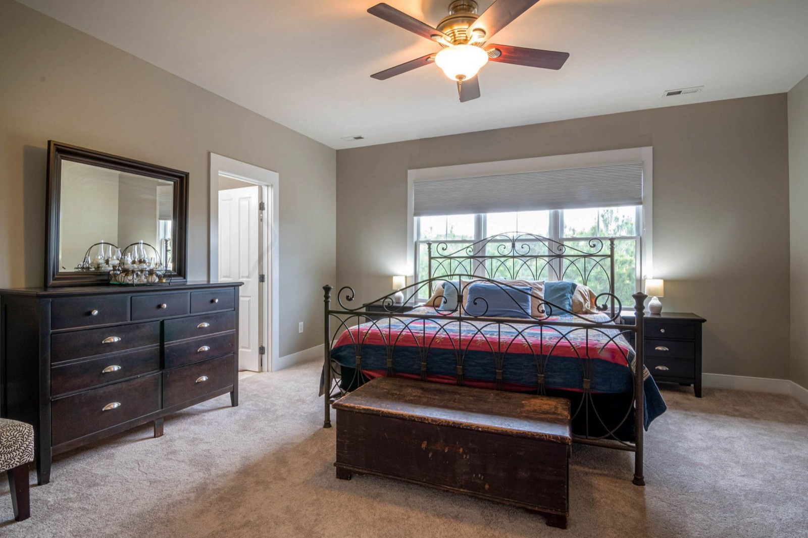 A bright, furnished bedroom with a real bed, dresser, and natural light, similar to a furnished apartment interior