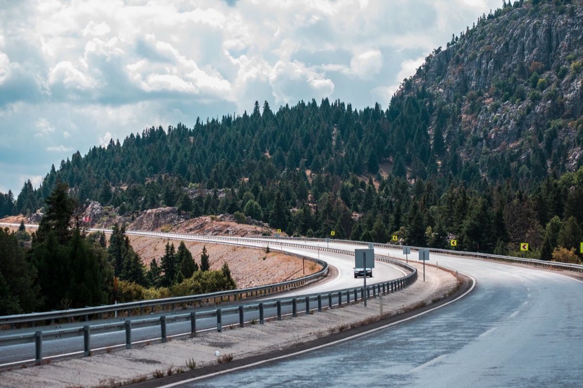 A winding mountain highway climbing through pine forest, similar to the route from Phoenix up to Pinetop, AZ