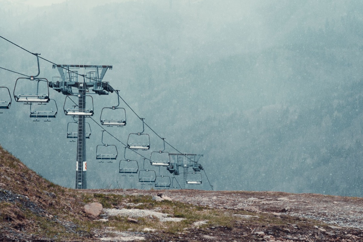 Ski lift towers rising through a snowy, fog-covered mountainside, similar to the lift lines at Sunrise Park Resort